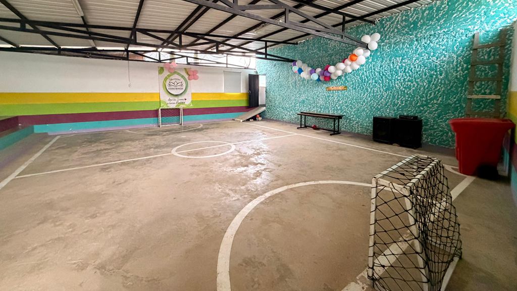 Así está hoy el salón: piso de cemento con líneas de microfútbol, un arco y paredes pintadas, sin mobiliario ni equipos.